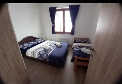 two beds in a small room with a window at Ugodan Kutak in Kupres