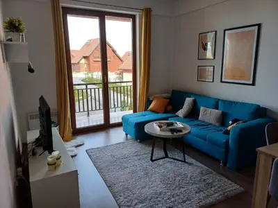 a blue couch in a living room with a window at Ugodan Kutak in Kupres