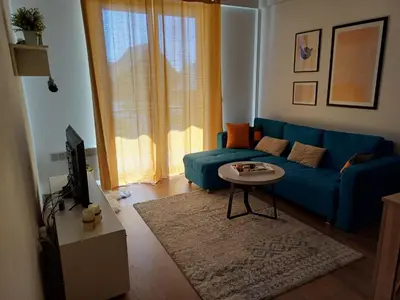 a living room with a blue couch and a table at Ugodan Kutak in Kupres