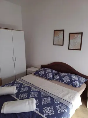 a bedroom with a bed with blue and white sheets at Ugodan Kutak in Kupres