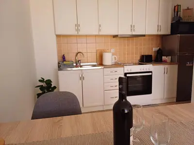a bottle of wine sitting on a table in a kitchen at Ugodan Kutak in Kupres