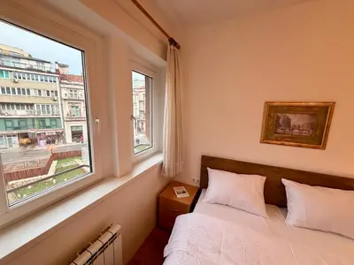 a bedroom with a bed and a large window at Apartments by BENCO in Ivišovo Greblje