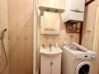 a bathroom with a sink and a washing machine at Apartments by BENCO in Ivišovo Greblje