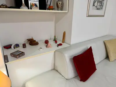 a white couch with a red pillow in a room at Apartments by BENCO in Ivišovo Greblje
