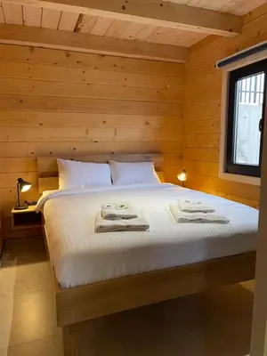 a bedroom with a bed with white sheets and a window at Kozara Panoramic Resort in Bosanska Gradiška