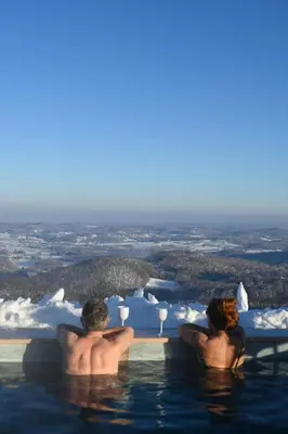 two men sitting in a swimming pool with a glass of wine at Kozara Panoramic Resort in Bosanska Gradiška