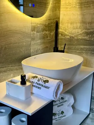 a bathroom with a sink and towels on a shelf at Kozara Panoramic Resort in Bosanska Gradiška