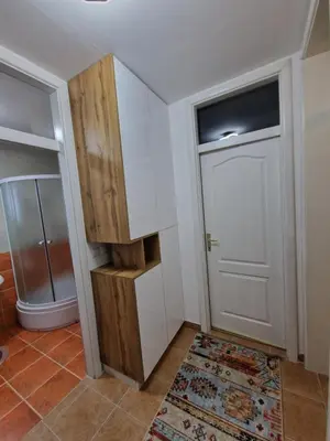 a bathroom with a white door and a rug at Apartman Miki in Vlasic