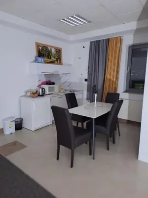 a dining room with a table and chairs and a kitchen at Prenoćište Durić in Cazin