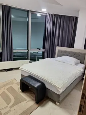 a bedroom with a bed with a bench in front of a window at Prenoćište Durić in Cazin