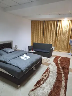 a bedroom with a bed and a couch and a rug at Prenoćište Durić in Cazin