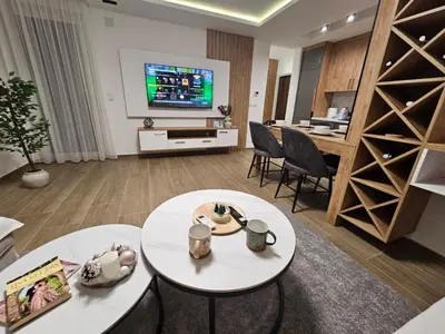a living room with two tables and a flat screen tv at Apartman IVA in Modriča