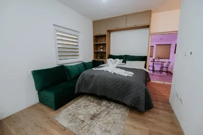 a living room with a green couch and a bed at Villa Žigić