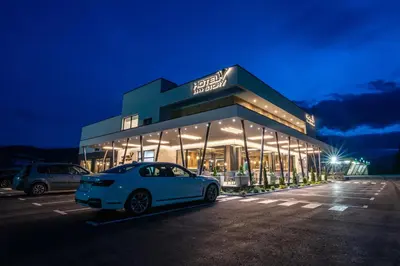 a car parked in front of a building at night at Hotel Story in Žepče