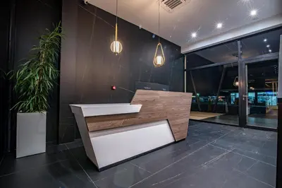 a lobby with a reception desk and potted plants at Hotel Story in Žepče