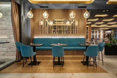 a dining room with a blue bench and chairs at Hotel Story in Žepče
