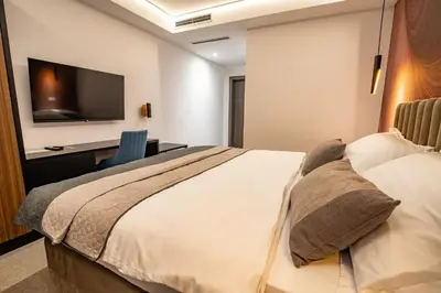 a bedroom with a bed and a desk and a television at Hotel Story in Žepče