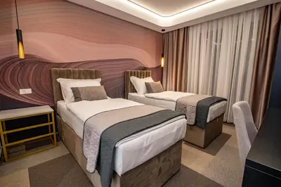 a hotel room with two beds and a tv at Hotel Story in Žepče