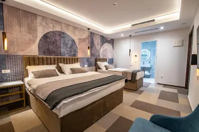 a bedroom with a large bed and a chair in it at Hotel Story in Žepče