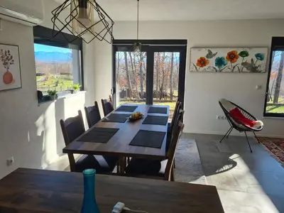 a dining room with a wooden table and chairs at Villa Aria in Bosanska Krupa