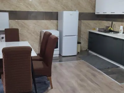 a kitchen with a table and a refrigerator at Apartman Mona Liza Banja Luka in Banja Luka