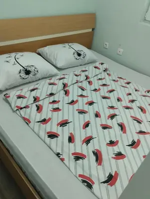 a bed with a red and white blanket on it at Apartman Mona Liza Banja Luka in Banja Luka