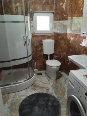 a bathroom with a shower and a toilet and a sink at Apartman Mona Liza Banja Luka in Banja Luka