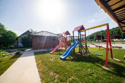 a playground with a slide in the grass at Una Relax in Vajagići