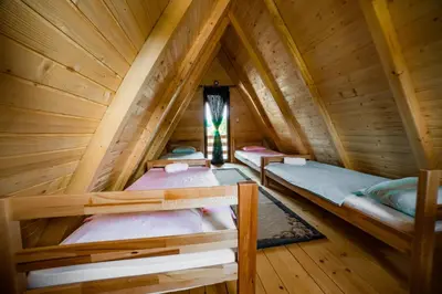 two bunk beds in a wooden cabin with a window at Una Relax in Vajagići