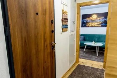 a door leading to a living room with a table at SkyLux Vlašić in Šišava