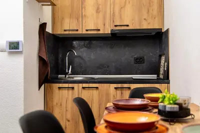 a kitchen with a sink and a table with bowls at SkyLux Vlašić in Šišava