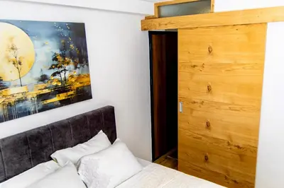 a bedroom with a bed and a wooden closet at SkyLux Vlašić in Šišava
