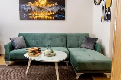 a living room with a green couch and a table at SkyLux Vlašić in Šišava