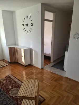 a room with a clock on the wall and a chair at Stan na Adi in Ivišovo Greblje