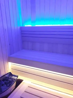 a sauna with a bench with a blue and green light at SPA APARTMAN Prijedor in Prijedor
