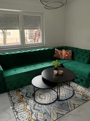a green couch in a living room with a table at SPA APARTMAN Prijedor in Prijedor