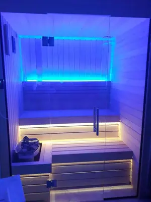 a walk in shower with blue and white lights at SPA APARTMAN Prijedor in Prijedor