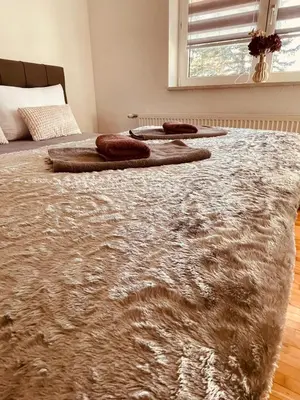 a bedroom with a bed with a rug on it at Apartman Šimić in Kupres