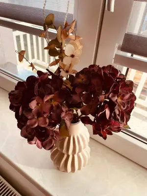 a vase filled with flowers sitting on a window sill at Apartman Šimić in Kupres