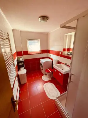 a red and white bathroom with a toilet and a sink at Apartman Šimić in Kupres
