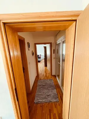 a hallway with a door open to a room with a rug at Apartman Šimić in Kupres