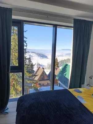a bedroom with a bed and a large window at Vlašić Grand View in Vlasic