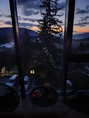 a room with a table and a view of a tree at Vlašić Grand View in Vlasic