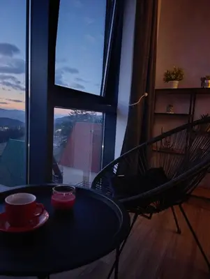 a table and a chair in front of a window at Vlašić Grand View in Vlasic