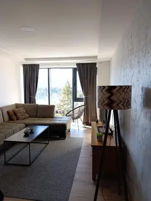 a living room with a couch and a table at Vlašić Grand View in Vlasic