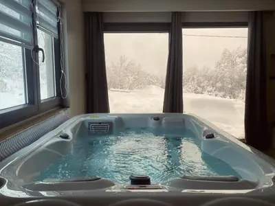 a jacuzzi tub in a room with a window at Relax house - Šumska vila romanticni spa apartman sa djakuzijem in Banja Luka