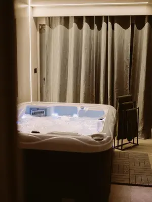 a hot tub in a room with a curtain at Relax house - Šumska vila romanticni spa apartman sa djakuzijem in Banja Luka
