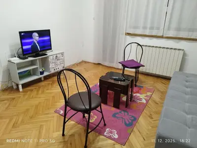 a living room with two chairs and a tv at Gold Mejdan in Banja Luka