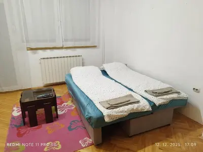 a small bedroom with a bed and a rug at Gold Mejdan in Banja Luka