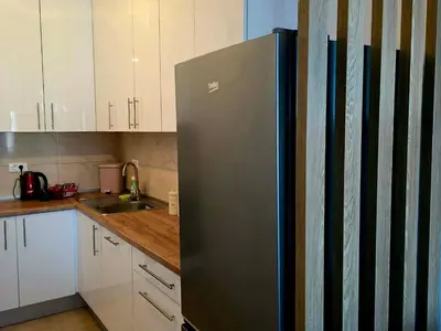 a stainless steel refrigerator in a kitchen with white cabinets at Novicasa in Železnička Stanica Incel